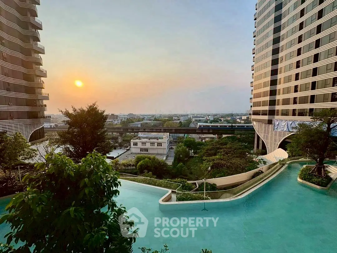 Stunning view of modern high-rise buildings with a serene pool and sunset backdrop.