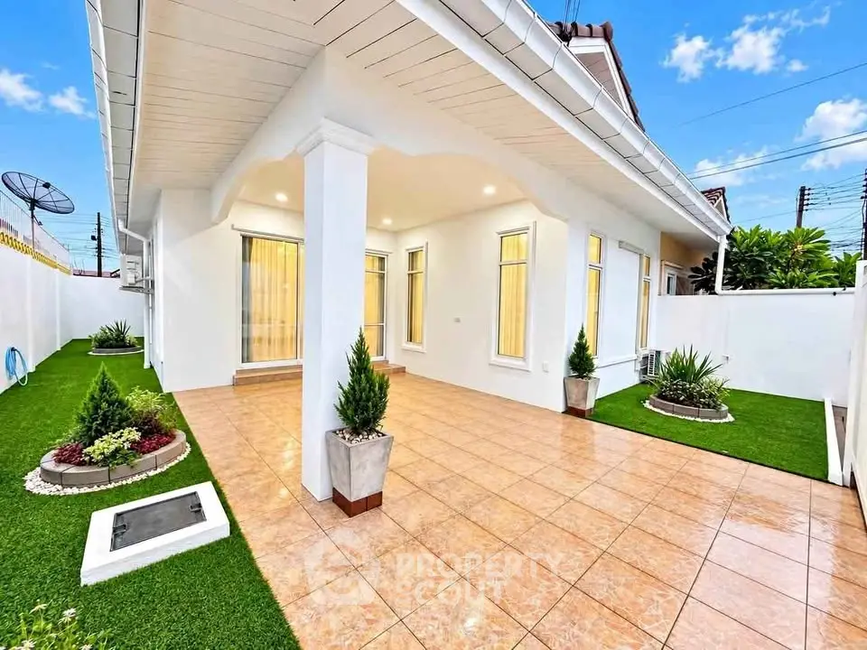Charming single-story home with tiled patio and lush garden, perfect for outdoor relaxation.