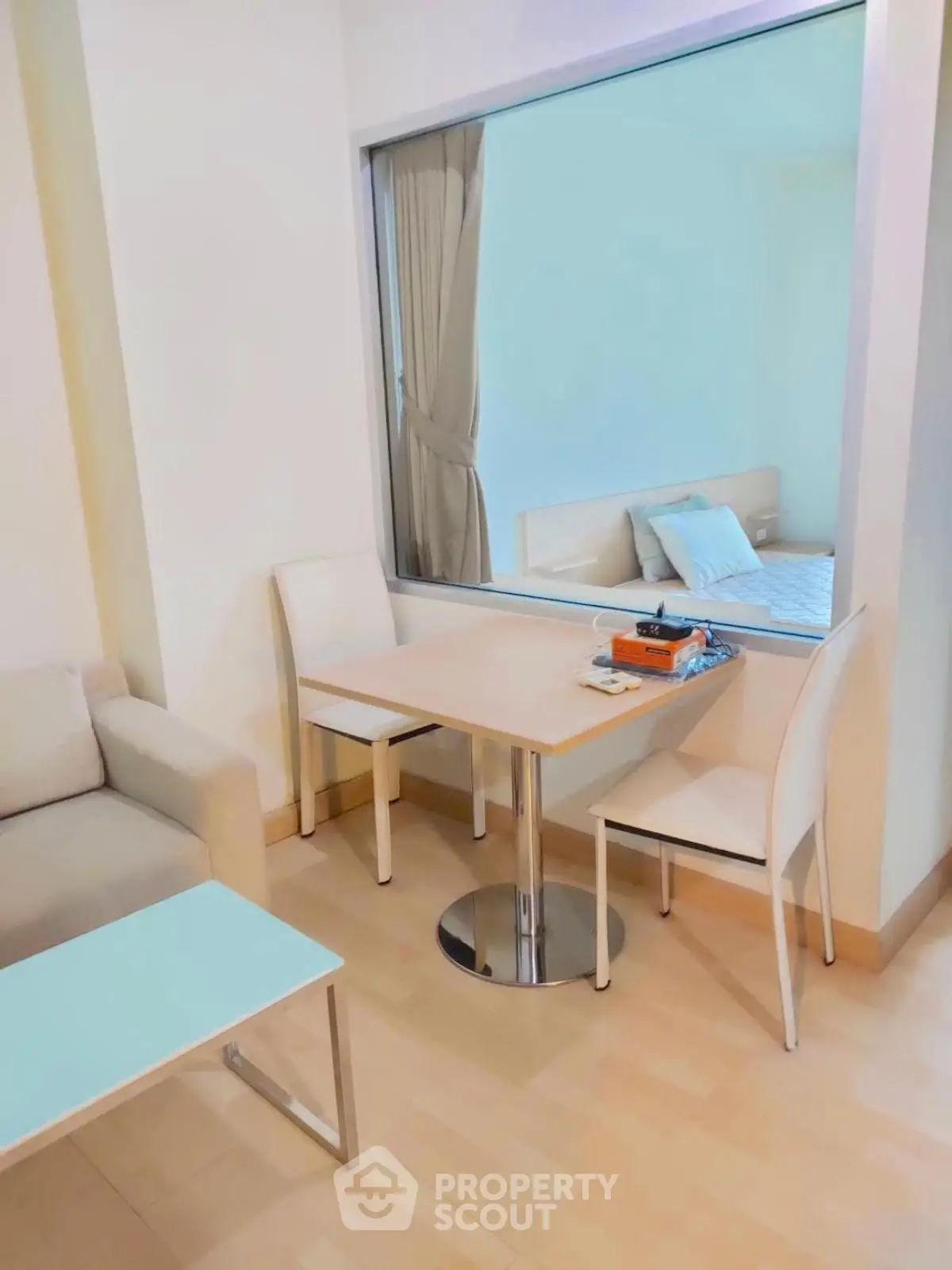 Cozy living area with modern furniture and a glimpse of a stylish bedroom