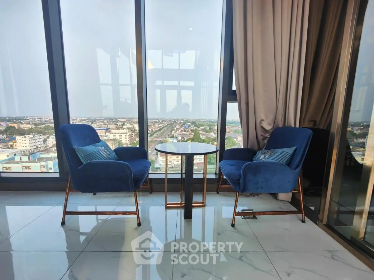 Luxurious high-rise apartment with stunning city view and elegant blue chairs