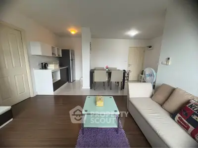 Spacious living room with modern kitchen and dining area in open layout apartment.