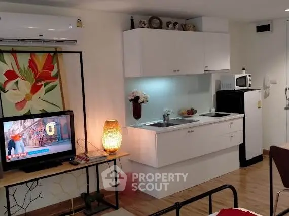 Cozy studio apartment with modern kitchenette and stylish decor, perfect for urban living.