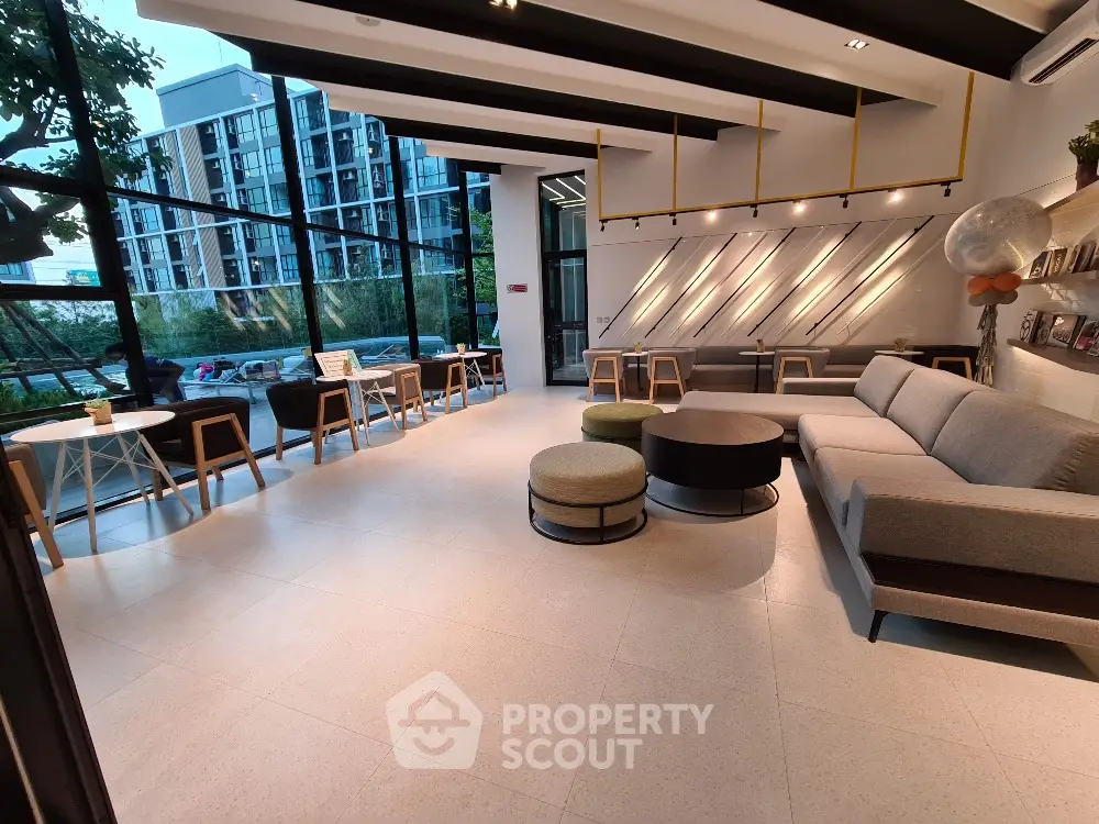 Modern and spacious living room with large windows and stylish furniture in a luxury apartment building.