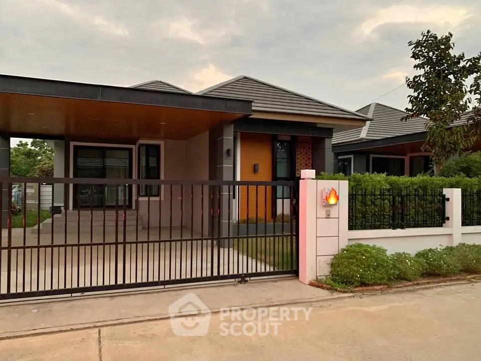 Modern single-story house with gated entrance and landscaped garden.