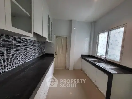 Modern kitchen with sleek black countertops and stylish backsplash