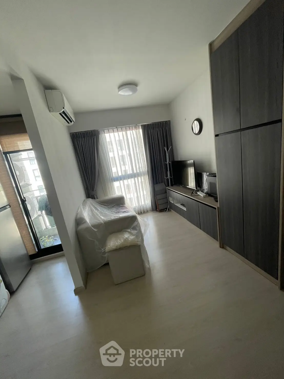 Modern living room with sleek furniture and natural light, featuring a balcony view.