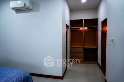 Spacious bedroom with built-in wardrobe and air conditioning unit.