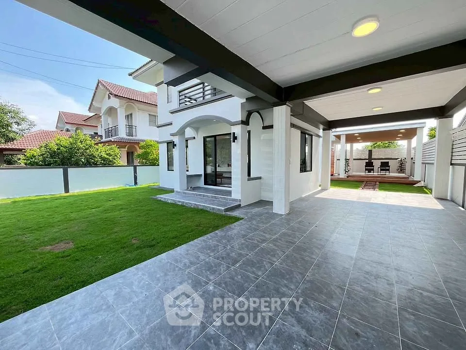 Spacious modern home with covered patio and lush green lawn