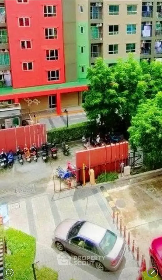 Vibrant apartment complex with parking and lush greenery