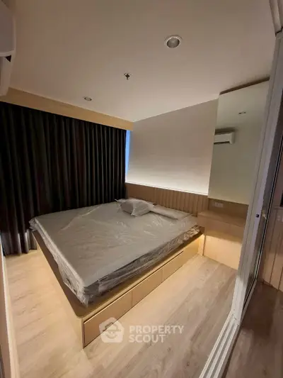 Modern bedroom with sleek design and ambient lighting, featuring a large bed and wooden flooring.