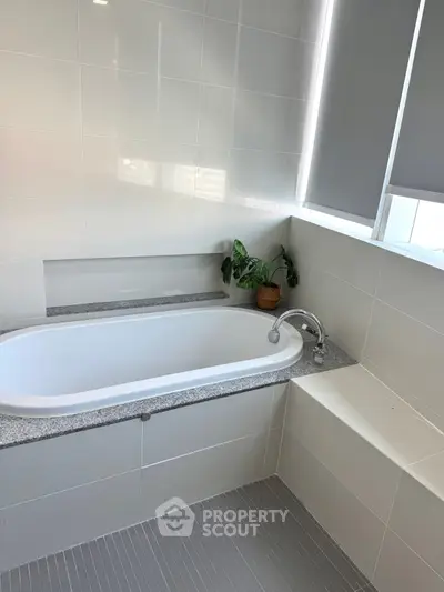 Modern bathroom with sleek bathtub and stylish tile design, perfect for relaxation and comfort.