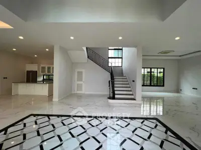 Spacious modern living room with elegant staircase and marble flooring