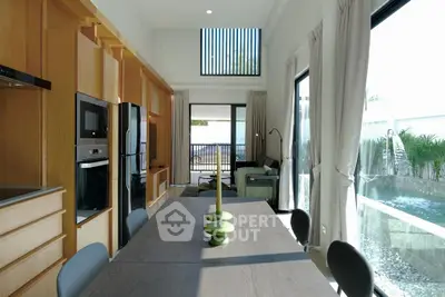 Modern open layout kitchen and dining area with pool view and natural light.