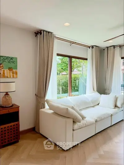 Elegant living room with large windows and cozy white sofa