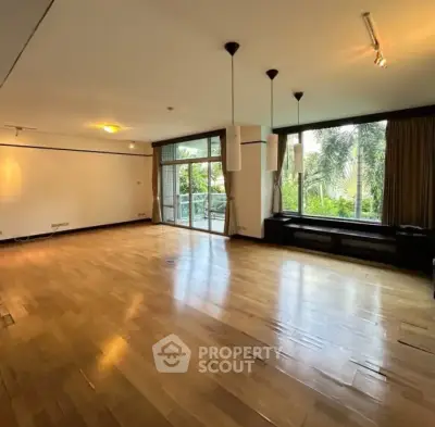 Spacious living room with large windows and garden view, perfect for modern living.