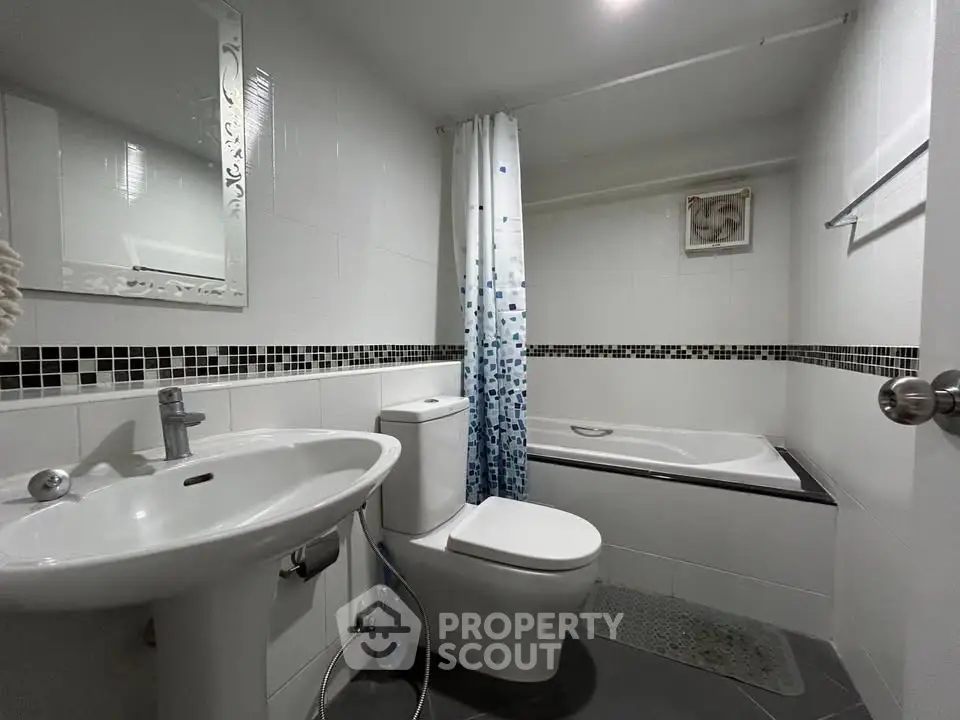 Modern bathroom with bathtub and stylish tile accents in a contemporary apartment.