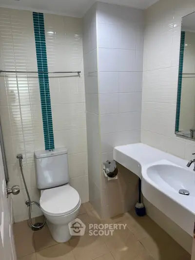 Modern bathroom with sleek white fixtures and stylish blue tile accents.