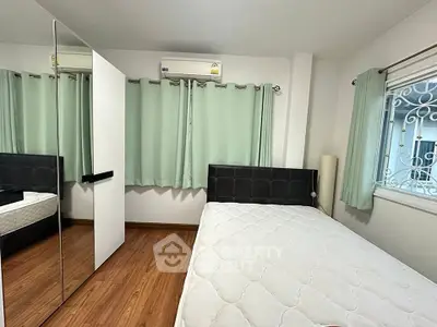 Cozy bedroom with mirrored wardrobe and air conditioning, perfect for restful nights.