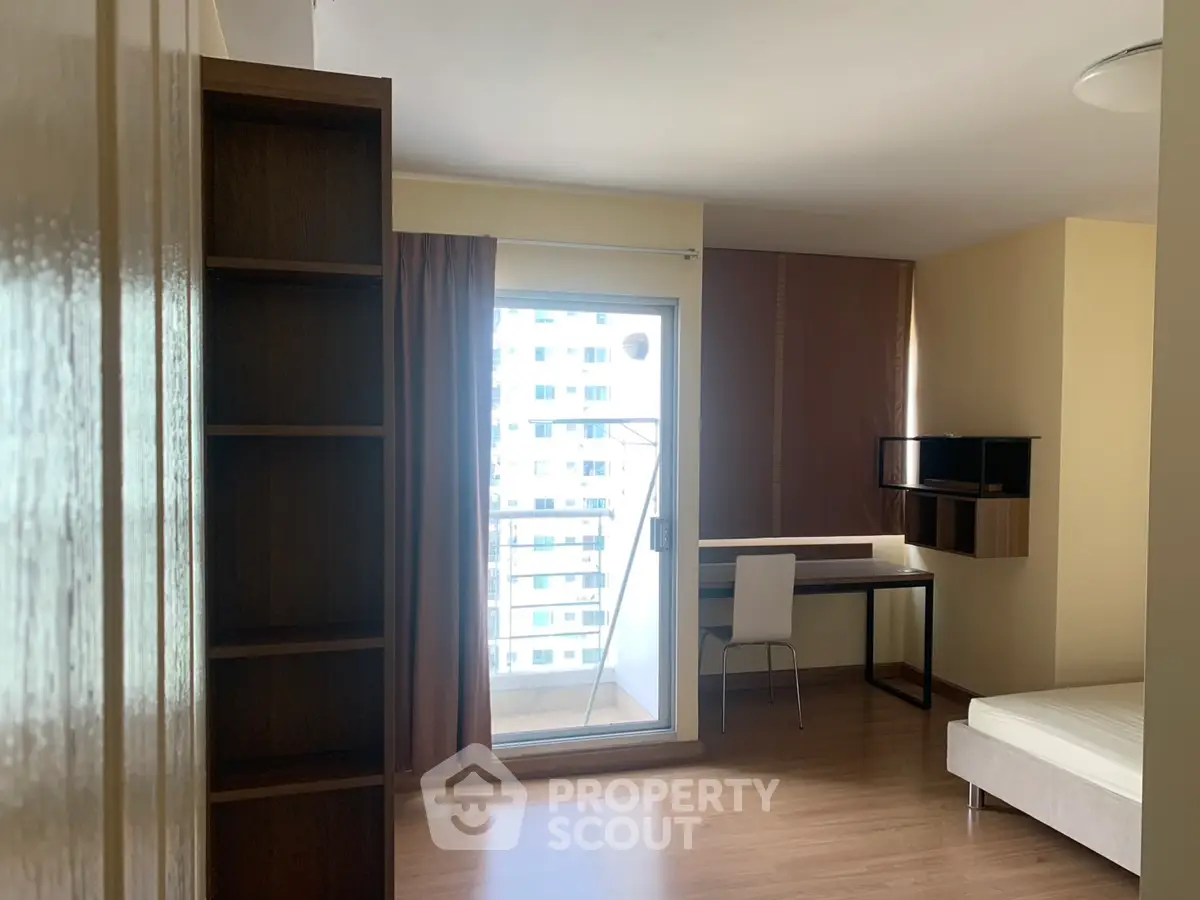 Modern apartment interior with balcony, study area, and natural light.