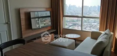 Modern living room with city view, featuring a cozy sofa and large TV, perfect for urban living.
