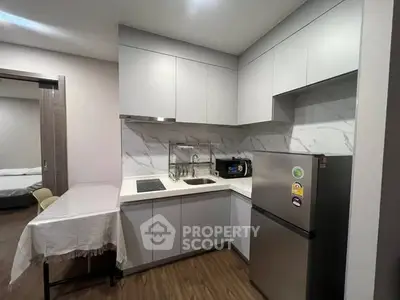 Modern kitchen with sleek cabinetry and compact dining area