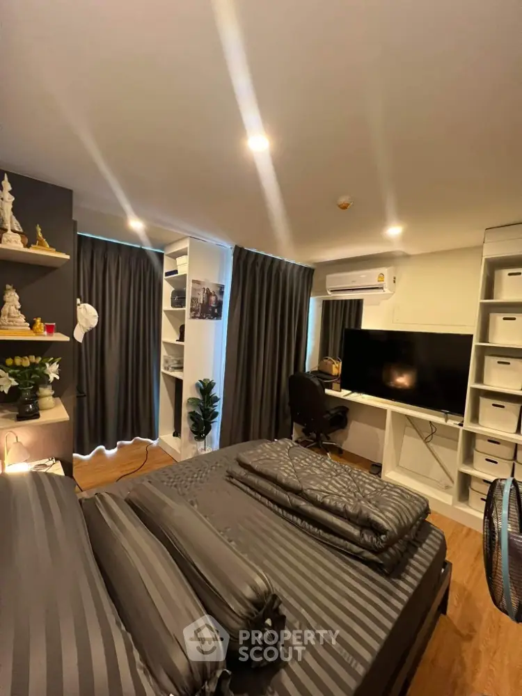 Modern bedroom with stylish decor, built-in shelves, and workspace setup