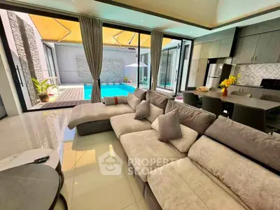 Luxurious living room with pool view and modern kitchen in open layout