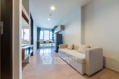 Modern living room with cozy sofa and large windows offering natural light.