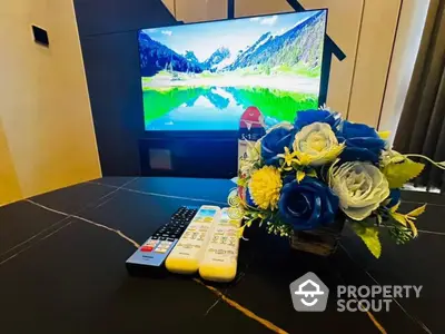 Modern living room with flat-screen TV and elegant floral arrangement