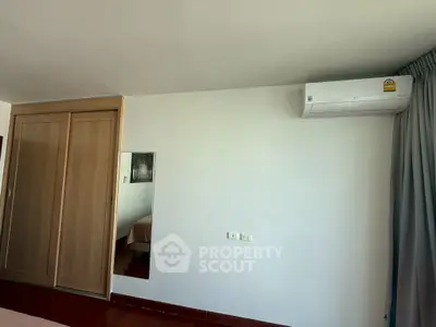 Spacious bedroom with built-in wardrobe and air conditioning unit