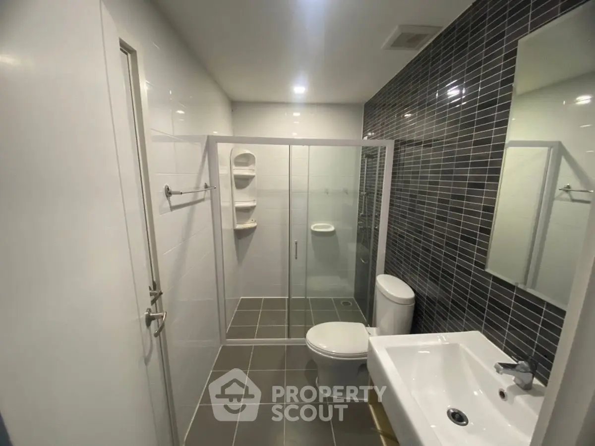 Modern bathroom with sleek glass shower and contemporary fixtures.