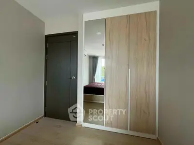 Modern bedroom with sleek wardrobe and wooden flooring in a stylish apartment.