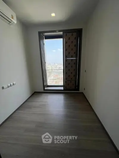 Bright empty room with large window and city view, perfect for customization.