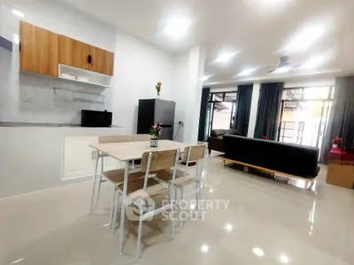 Spacious open-plan living and dining area with modern kitchen in a bright, airy apartment.