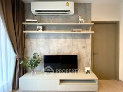 Modern living room with stylish decor and wall-mounted air conditioner.