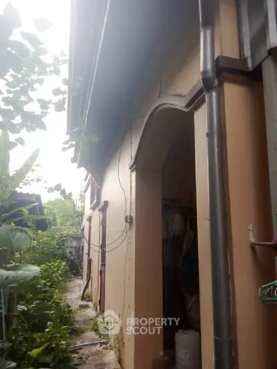 Charming rustic exterior with lush greenery and arched entrance