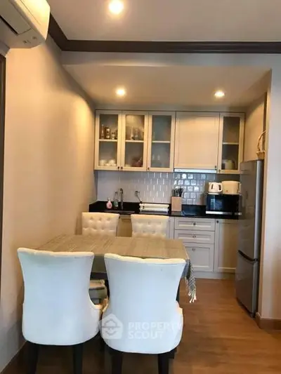 Cozy kitchen with dining area, featuring modern appliances and elegant cabinetry.