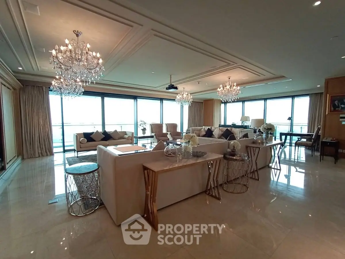 Luxurious living room with chandeliers and panoramic windows offering stunning views.