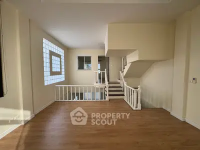 Spacious interior with modern staircase and wooden flooring, perfect for stylish living.