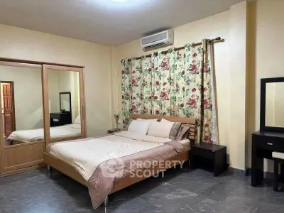 Spacious bedroom with floral curtains and modern furnishings