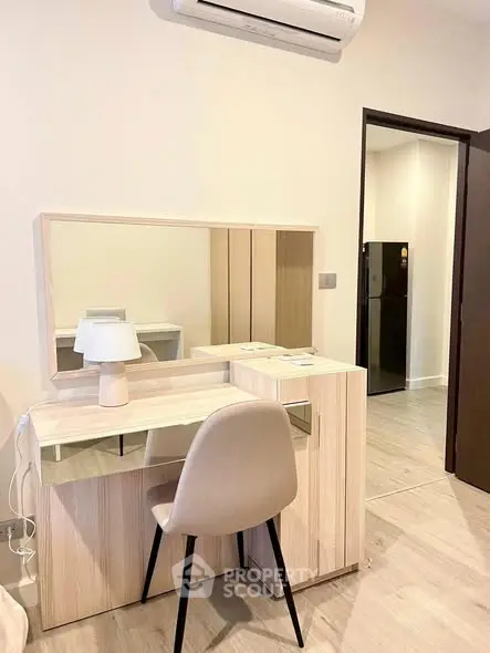Modern bedroom with stylish vanity and chair, featuring a sleek design and neutral tones.