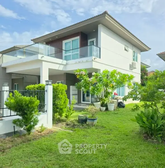 Modern two-story house with lush garden and spacious balcony in a serene neighborhood.