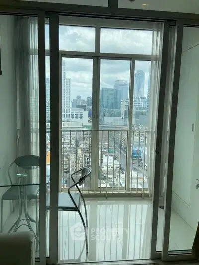 Modern apartment with stunning city view from glass balcony doors.