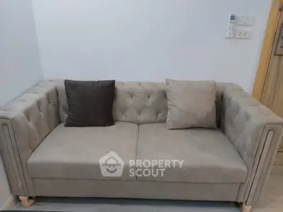 Modern living room with stylish beige sofa and decorative cushions