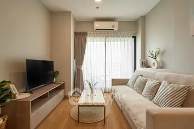 Modern living room with cozy sofa, TV, and natural light from large window.