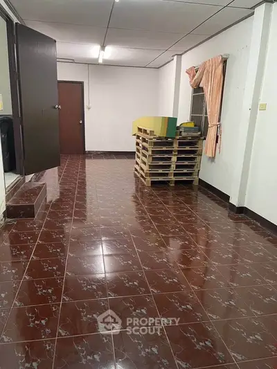 Spacious room with tiled flooring and simple decor, ideal for versatile use.
