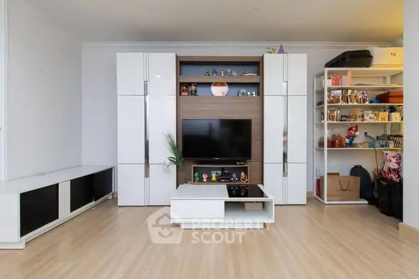 Modern living room with sleek white cabinetry and wooden flooring