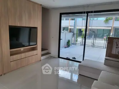 Modern living room with large TV and sliding glass doors to patio