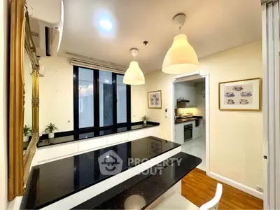 Modern kitchen with sleek black countertops and elegant pendant lighting