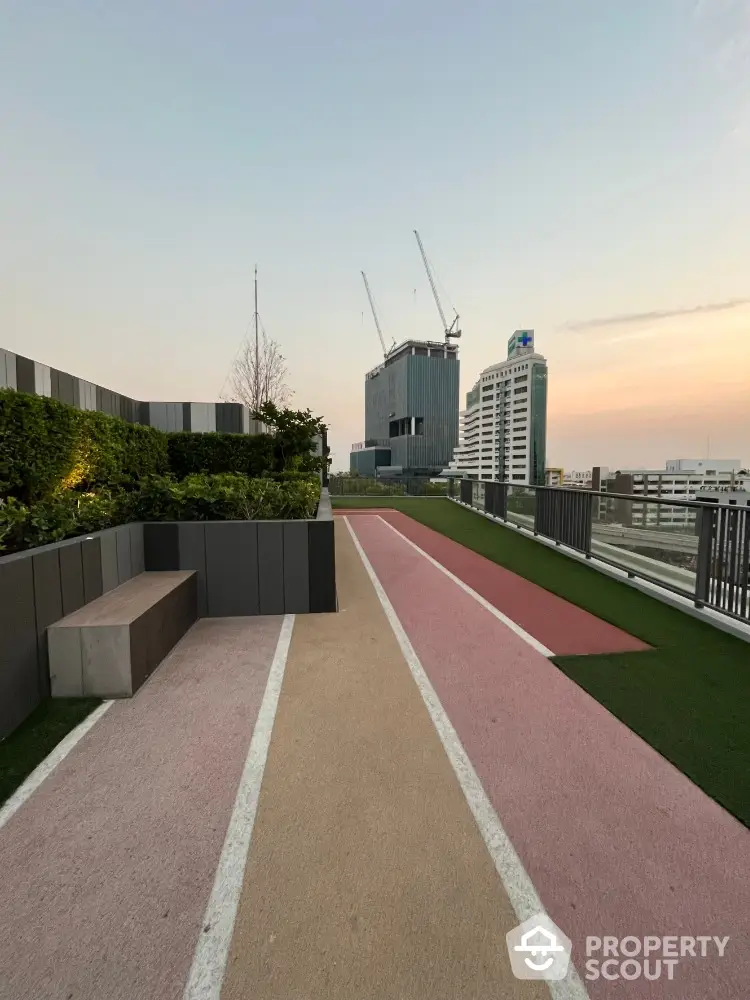 Modern rooftop jogging track with city skyline view at sunset